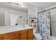 Bathroom features single sink vanity, tile flooring, and shower with blue floral curtain at 8336 Golden Amber St, Las Vegas, NV 89139