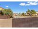 View of a community recreation area with basketball court and lush landscaping beyond the back wall at 8336 Golden Amber St, Las Vegas, NV 89139