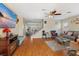 Bright living room featuring hardwood floors, a ceiling fan, and a staircase leading to the second floor at 8336 Golden Amber St, Las Vegas, NV 89139