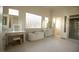 Bright bathroom features a soaking tub, vanity with lighted mirror, glass block window, and a separate shower at 9 Knob Oak Dr, Henderson, NV 89052