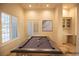 Bright game room featuring a sleek pool table, wet bar, and sunlit windows with white shutters for a relaxing atmosphere at 9 Knob Oak Dr, Henderson, NV 89052