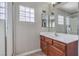 Bathroom featuring a walk-in shower, vanity with cabinets, and a glass block window at 9005 Semillon St, Las Vegas, NV 89148