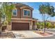 Two-story home with a brown garage door, mature trees, and desert landscaping with rock ground cover at 9005 Semillon St, Las Vegas, NV 89148