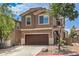 Charming two-story home with a brown garage door, a well-manicured yard, and beautiful trees at 9005 Semillon St, Las Vegas, NV 89148