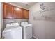 Laundry room with upper cabinets, storage shelves, and modern washer and dryer at 9005 Semillon St, Las Vegas, NV 89148