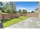 An enclosed backyard with a newly installed lawn, a small tree, and a patio. A modern design offers privacy at 9105 White Eyes Ave, Las Vegas, NV 89143