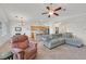 Open-concept living room featuring a ceiling fan, carpet flooring, and view of the kitchen at 9105 White Eyes Ave, Las Vegas, NV 89143