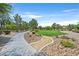 Scenic community park view featuring a paved walking path, trees, lush green space, and decorative landscaping at 9105 White Eyes Ave, Las Vegas, NV 89143
