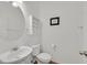 Bright powder room features a pedestal sink, toilet, and decorative wall shelf at 9105 White Eyes Ave, Las Vegas, NV 89143