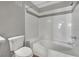 Bright bathroom featuring a tiled shower and tub combination, plus a toilet and bench seat at 950 Seven Hills Dr # 124, Henderson, NV 89052