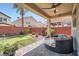 Backyard offers a covered patio, putting green, desert landscaping, and privacy fence at 9853 Bangalore Ct, Las Vegas, NV 89148