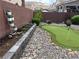 Landscaped backyard with putting green, rock garden, brick wall and decorative ladder planter display at 9853 Bangalore Ct, Las Vegas, NV 89148