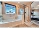 Bright bathroom with a soaking tub, glass-enclosed shower, and view to the main bedroom at 9853 Bangalore Ct, Las Vegas, NV 89148