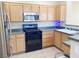 Kitchen area featuring light wood cabinets and black gas range at 10190 Deerfield Beach Ave # 202, Las Vegas, NV 89129