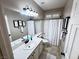 Bathroom featuring a single sink vanity, framed mirrors, and a shower/tub combo with white tiled walls at 10248 Maggira Pl, Las Vegas, NV 89135