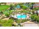 Aerial view of a stunning community pool surrounded by green trees and manicured landscaping in a golf community at 10248 Maggira Pl, Las Vegas, NV 89135