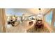 Open-concept living spaces featuring tile flooring, a kitchen island, and natural light from the windows at 10248 Maggira Pl, Las Vegas, NV 89135