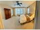 Bright main bedroom with a ceiling fan, bay window, shutters, neutral carpet, and an elegant armoire at 10248 Maggira Pl, Las Vegas, NV 89135