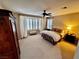 Spacious main bedroom featuring neutral decor, plush carpet, shuttered windows, and a ceiling fan for added comfort at 10248 Maggira Pl, Las Vegas, NV 89135