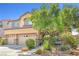 Inviting home featuring desert landscaping, a three-car garage, and mature shade trees at 1141 Brent Park Ct, Henderson, NV 89002