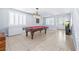 Bright and open living space with tile flooring, a pool table, and modern white shutters at 1141 Brent Park Ct, Henderson, NV 89002