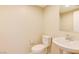 Powder room with a toilet, sink, and mirror at 11840 Pelican Butte Ave, Las Vegas, NV 89138