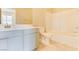 This bathroom features a shower over the tub, a modern sink, and neutral tiling at 11840 Pelican Butte Ave, Las Vegas, NV 89138
