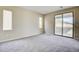 Spacious bedroom featuring neutral walls, plush carpeting and access to a large outdoor balcony at 11840 Pelican Butte Ave, Las Vegas, NV 89138
