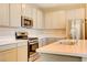Beautiful kitchen with stainless appliances, island sink, light countertops, and light wood cabinets at 11840 Pelican Butte Ave, Las Vegas, NV 89138