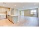 Open-concept living room featuring wood-look flooring, natural light, and flowing into a kitchen with stainless appliances at 11840 Pelican Butte Ave, Las Vegas, NV 89138