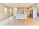Spacious open-concept living space featuring wood-look flooring, natural light, and flowing into a kitchen area at 11840 Pelican Butte Ave, Las Vegas, NV 89138