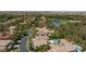 Areal view of a neighborhood with multiple homes, lush greenery, a golf course and a pond at 11926 Port Labelle Dr, Las Vegas, NV 89141