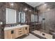 Modern bathroom with a double sink vanity and glass enclosed shower with brown marble at 11926 Port Labelle Dr, Las Vegas, NV 89141