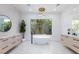 This bathroom features a modern tub, dual vanities, and abundant natural light at 11926 Port Labelle Dr, Las Vegas, NV 89141