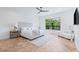 Bright bedroom with a large window, hardwood floors, and a plush bed and chair at 11926 Port Labelle Dr, Las Vegas, NV 89141
