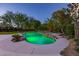 An in-ground pool with lush landscaping and stone accents creates a serene backyard oasis at 11926 Port Labelle Dr, Las Vegas, NV 89141