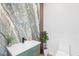 Unique powder room with marble wall and green vanity at 11926 Port Labelle Dr, Las Vegas, NV 89141