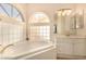 Bright bathroom featuring a soaking tub with tiled surround and modern fixtures at 1339 Echo Creek St, Henderson, NV 89052