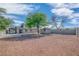 Spacious backyard featuring a large gravel area, mature trees, a storage shed, and block wall fencing at 1608 E Mcdonald Ave, North Las Vegas, NV 89030