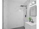 Modern bathroom featuring elegant marble-like tile, a rain shower head, and sleek fixtures at 1608 E Mcdonald Ave, North Las Vegas, NV 89030