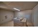 Unfinished laundry room showing concrete walls, a utility sink, and laundry hookups at 1608 E Mcdonald Ave, North Las Vegas, NV 89030