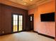 Spacious bedroom with neutral carpet, large windows, a tv, and a textured wall at 1800 Amarone Way, Henderson, NV 89012
