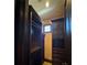 Dark wood closet with shelves, drawers, and glass cabinet door at 1800 Amarone Way, Henderson, NV 89012