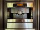 Close up of the Miele coffee maker and oven with black surround and stainless steel accents at 1800 Amarone Way, Henderson, NV 89012