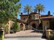Elegant home with wrought iron gate, lush landscaping, and a distinctive Mediterranean-style design at 1800 Amarone Way, Henderson, NV 89012