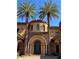 Stunning home entrance with tall palm trees, stone archway, and a unique turret design at 1800 Amarone Way, Henderson, NV 89012