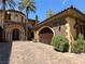 Mediterranean-style home with a spacious garage, stone accents, and beautifully landscaped grounds at 1800 Amarone Way, Henderson, NV 89012