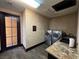 This laundry room features a modern washer and dryer, granite countertops, and direct access to the outside at 1800 Amarone Way, Henderson, NV 89012