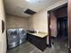 This laundry room features a modern washer and dryer, granite countertops, and custom cabinetry at 1800 Amarone Way, Henderson, NV 89012