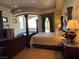 Serene main bedroom featuring a four-poster bed, fireplace, and balcony with picturesque views at 1800 Amarone Way, Henderson, NV 89012